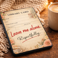 Phone with a library card design on screen next to a cup of coffee on a wooden surface.
